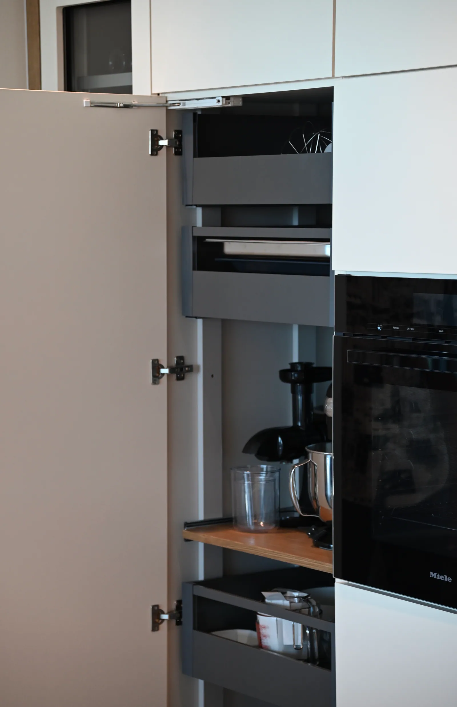 Tall cabinet open to show its internal pull-out storage