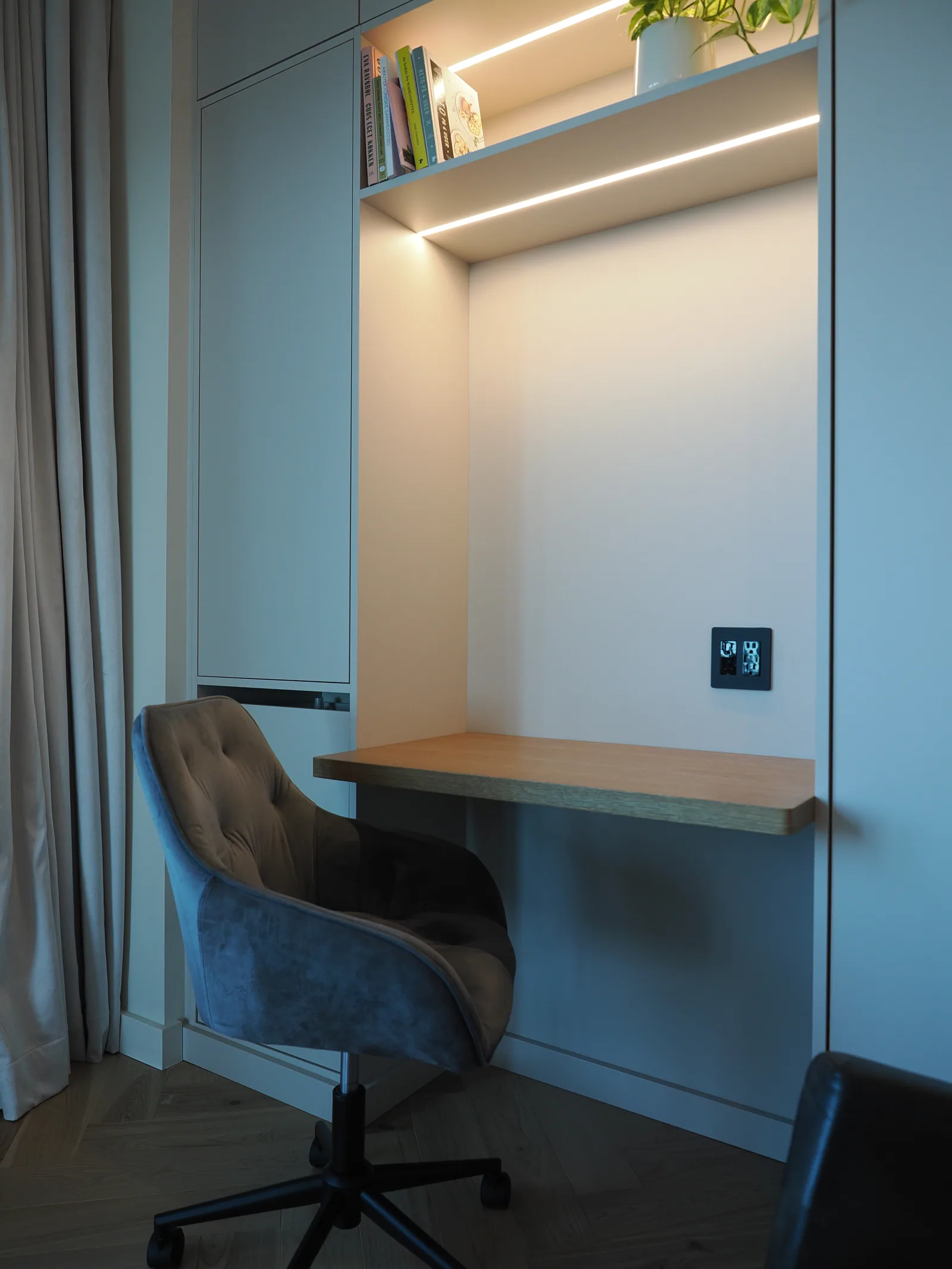 Wood desktop and linear task light within the office cabinetry