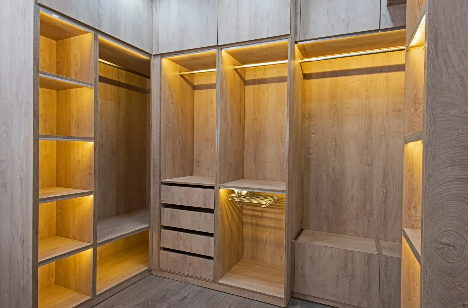Completed LeVika wood-finish closet with illuminated shelves, drawers and hanging rails