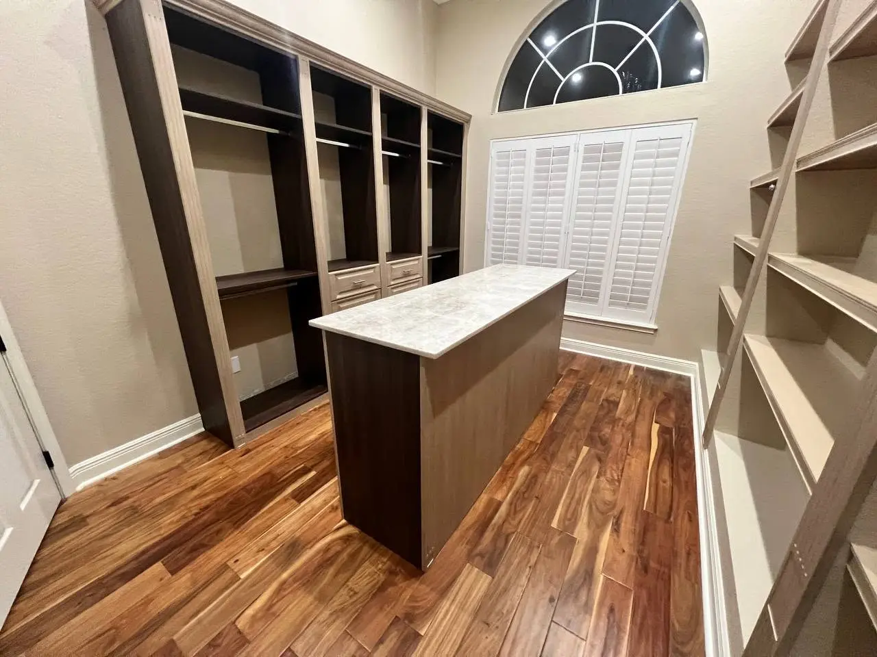 Completed mixed-wood walk-in closet with central island by LeVika Furniture